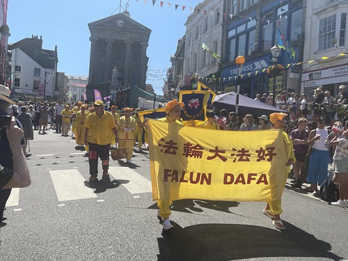 Image for article Penzance, Reino Unido: El equipo de tambores de cintura de Falun Dafa participa en el desfile del festival