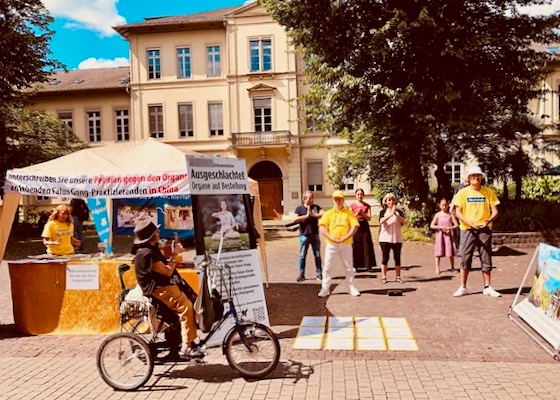 Image for article Alemania: El público condena los 25 años de persecución a Falun Gong durante un evento en Heidelberg