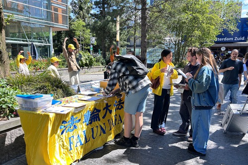 Image for article La gente anima a los practicantes de Falun Dafa durante un evento en el World Trade Center de Ámsterdam