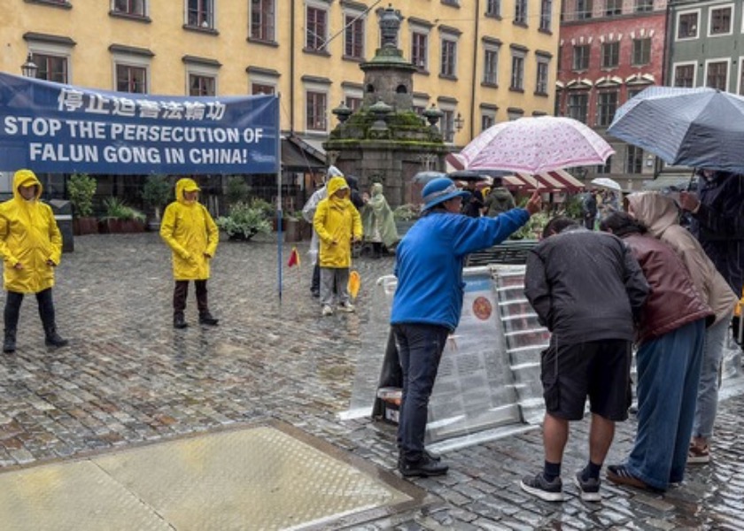 Image for article Personas firman una petición para poner fin a la persecución durante un evento frente al Museo del Premio Nobel en Estocolmo